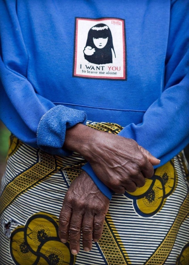 A woman's folded hands; the patch on her sweatshirt reads I want you to leave me alone.